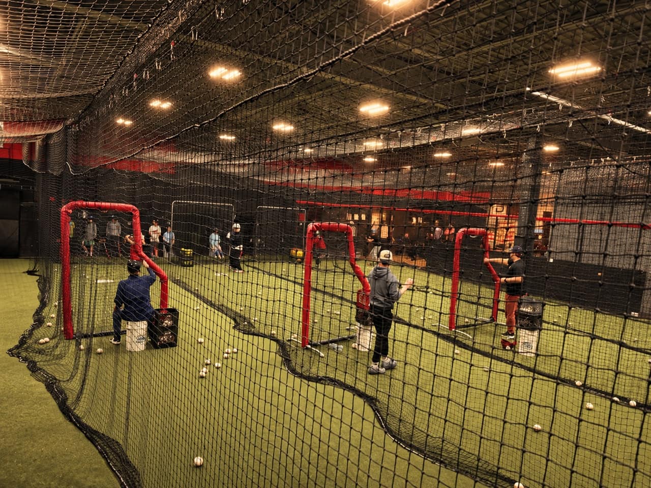 Coaches throwing batting practice in three cages
