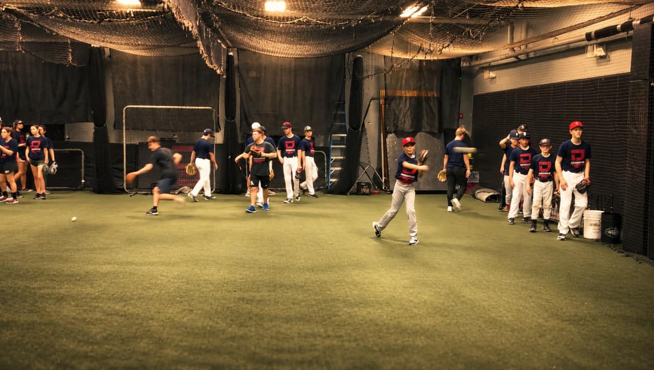 Players working a throwing and fielding drill on the academy turf